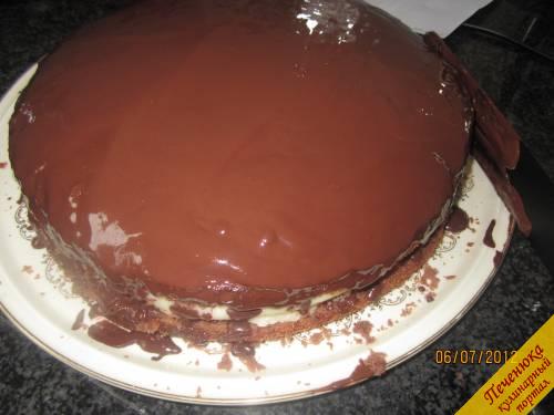 11) Шоколадную глазурь, не вынимая из пакетика, разогреваем в горячей воде. Отрезаем уголок пакетика и выдавливаем глазурь на остывший торт. Равномерно покрываем верх и бока торта.