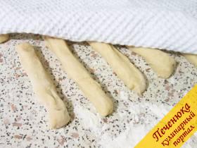 10) Пальцами, смазанными в растительном масле, слегка раскатать полоски и сложить их рядками. Накрыть эти жгутики из дрожжевого теста полотенцем и оставить на 10 минут. 