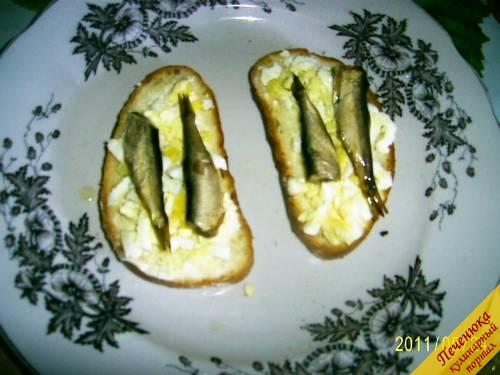 6) Поверх яйца положить по две рыбки из шпротных консервов. 