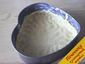 3) Форму для сырника смажем маргарином, обсыплем мукой. Тесто выложим тонким слоем на дно, сформуем небольшие бортики. 
