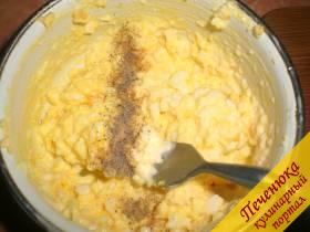 5) После к плавленому сырку добавляется сваренный вкрутую яичный желток (он измельчается при помощи вилки) и чеснок (при помощи пресса измельченный). Добавить черный молотый перец. Перемешать.