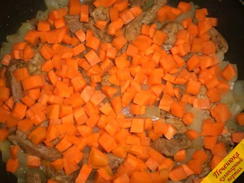 5) Также кубиками средней величины порезать сырую очищенную морковь. Укрыть ею перемешанный с индейкой лук. Накрыть крышкой и продолжить тушение 5 минут на слабом огне. 