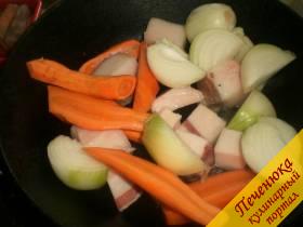 2) Почистить репчатый лук и морковь. Луковицу разрезать на 4 части, морковь режется длинными толстыми брусками. Советую в паштет добавить свиное сало без шкурки. Лук, морковь и сало выложить на хорошо разогретую сковороду. Накрыть крышкой и на маленьком огне потомить несколько минут. Сало должно пустить жир, но не подрумяниться. Периодически помешивать.