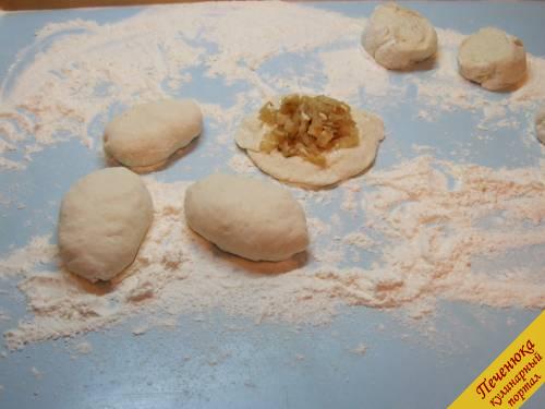 6) Поделить тесто на небольшие сегменты, руками аккуратно сформировать из них лепешки диаметром примерно с ладонь. Положить на центр начинку, защипнуть края и придать форму пирожка.